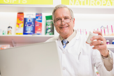 Smiling senior holding medication in the pharmacy